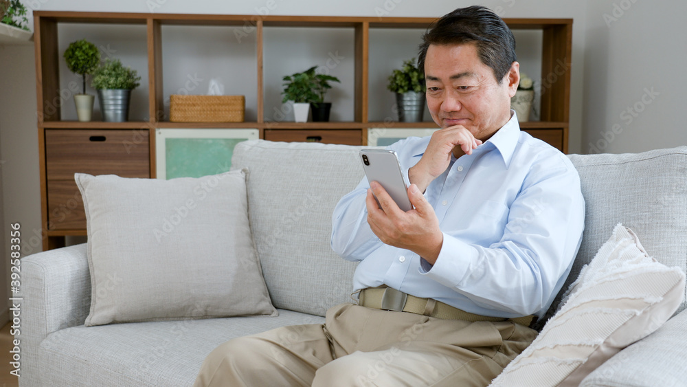 携帯電話を使う中年男性 携帯電話を使う中年男性