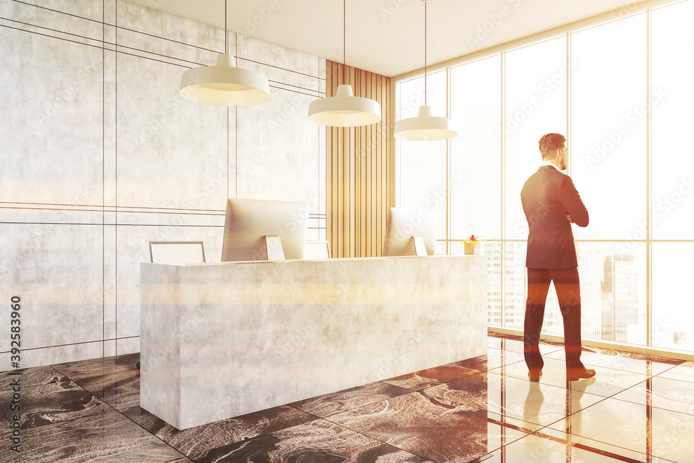 Man in white and marble office with reception