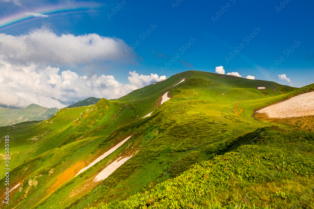 Beautiful mountain landscape at Caucasus mountains with clouds and blue sky..