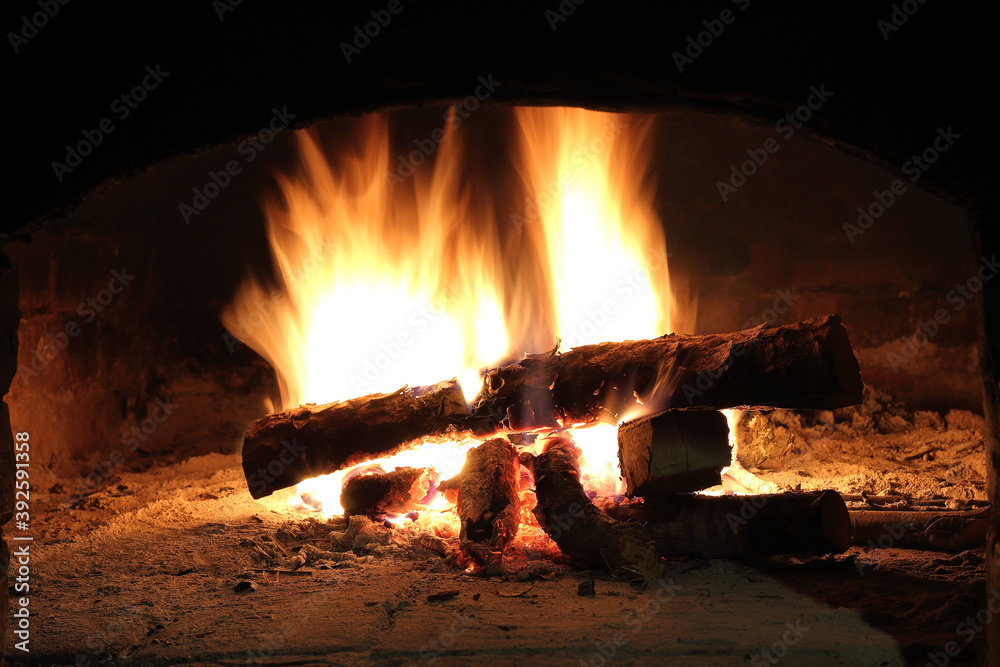brightly burning wood in the fireplace. warming atmosphere for a country house brightly burning wood in the fireplace. warming atmosphere for a country house