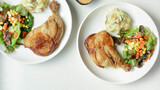 plate of delicious grilled chicken legs steak with vegetable and salad potato on white background