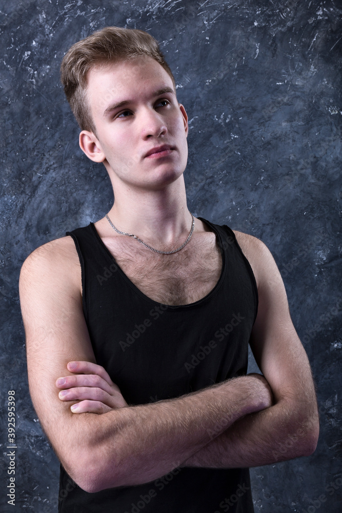 Young sportsman dressed in black vest studio portrait.