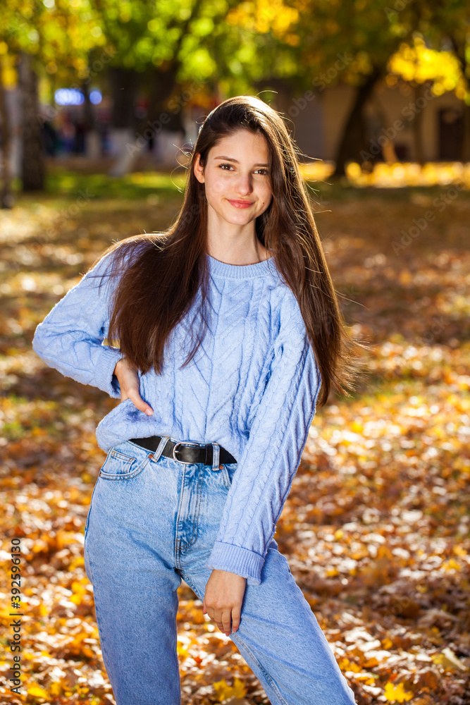 Portrait of a young girl in blue sweater, autumn park outdoor Portrait of a young girl in blue sweater, autumn park outdoor