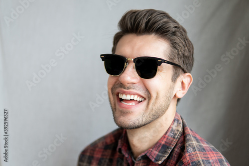 Portrait of a happy young man in black sunglasses and beautiful big smile looking in to the camera 