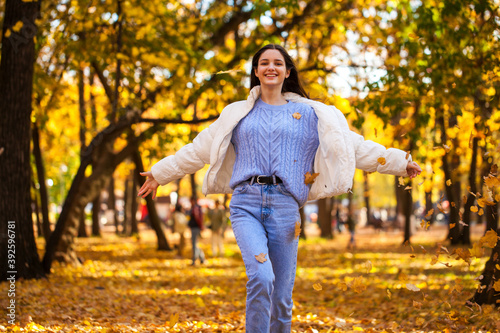 Happy young girl running in the autumn park