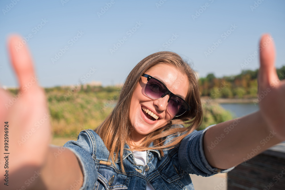 Pretty blonde girl makes selfie on smartphone