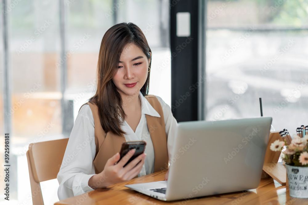 Young asian businesswoman beautiful charming smiling and using on mobile phone in the office. Young asian businesswoman beautiful charming smiling and using on mobile phone in the office.