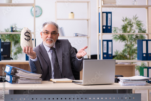 Old male employee holding moneybag in retirement concept