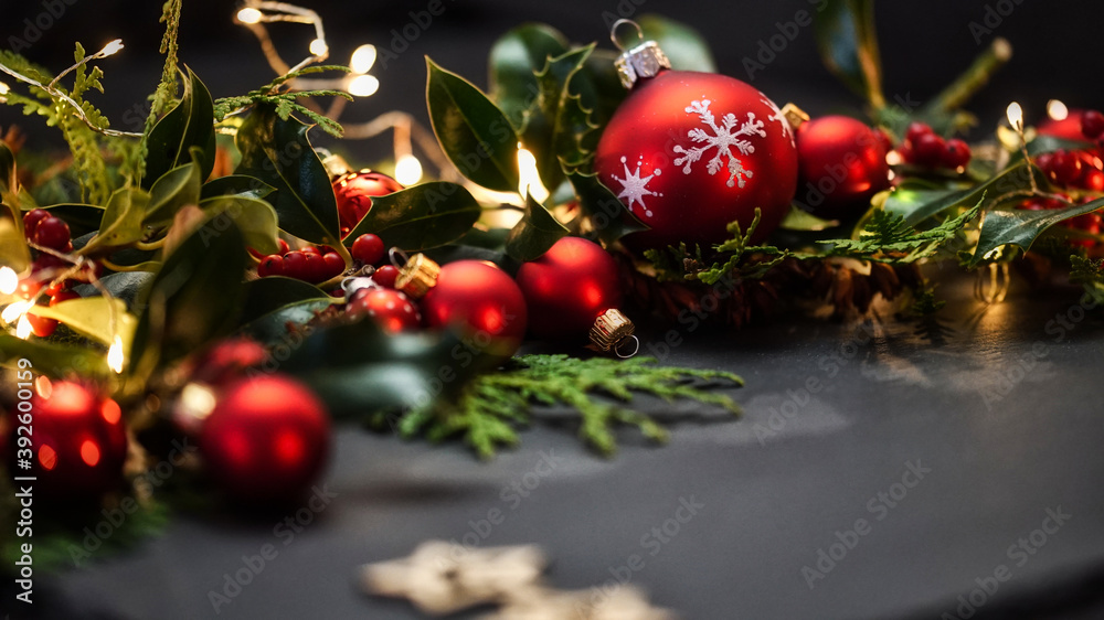 Christmas Balls and wooden stars with green leaves on dark Background
