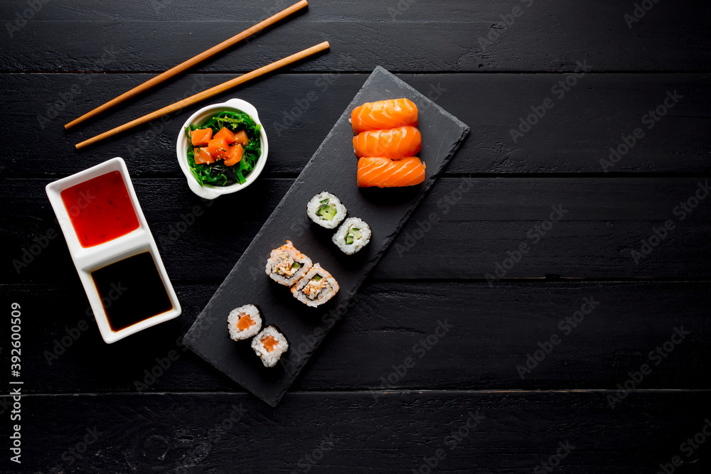 Sushi Set sashimi and sushi rolls on stone slate