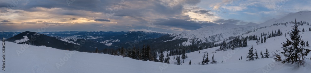 Picturesque winter windy and cloudy morning alps. Ukrainian Carpathians highest ridge Chornohora with peaks of Hoverla and Petros mountains. View from Svydovets ridge  Dragobrat ski resort.