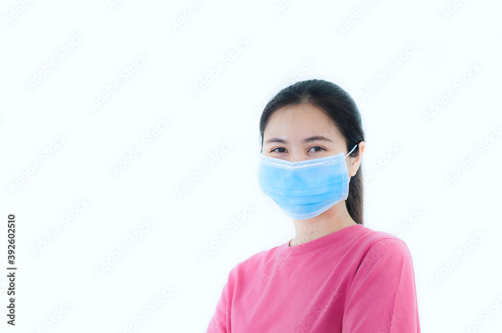 Close-up portrait of A beautiful teenage asian woman wearing a pink T-shirt and a blue medical face mask. isolated on white background. Close-up portrait of A beautiful teenage asian woman wearing a pink T-shirt and a blue medical face mask. isolated on white background.