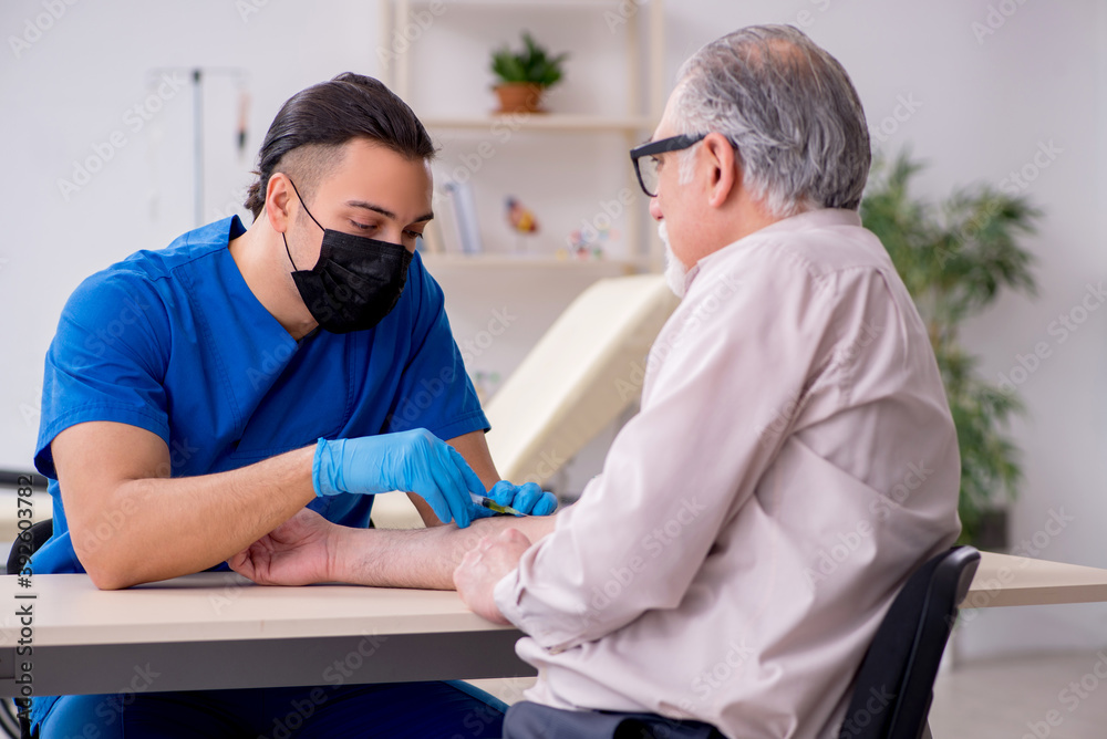 Fototapeta premium Old patient visiting young male doctor in blood transfusion conc
