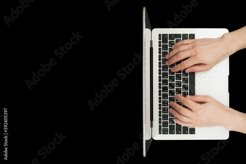 Top view of businessman hands busy using laptop at black office desk.