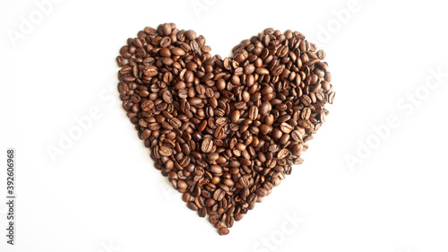Coffee beans laid out in the shape of a heart on a white background. © Artjom