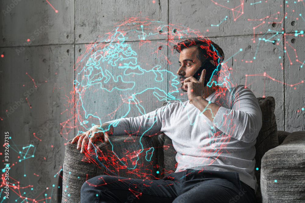 Obraz premium A man in casual wears, speaks phone. Double exposure. Planet Earth World map hologram.