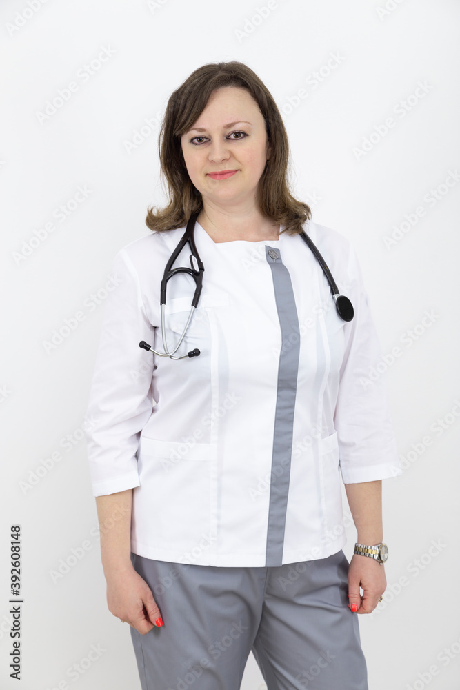 Adult female doctor with a stethoscope against a white wall. experienced doctor who inspires confidence. Woman hospital worker looking at camera. Adult female doctor with a stethoscope against a white wall. experienced doctor who inspires confidence. Woman hospital worker looking at camera.