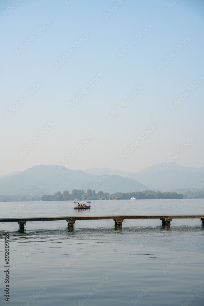 The mountain and lake landscape at West Lake in Hangzhou, China, on a sunny day.