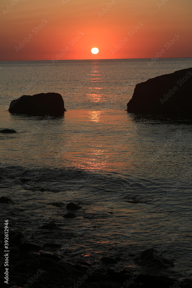 Beautiful sunrise over the sea and stones in the water Beautiful sunrise over the sea and stones in the water