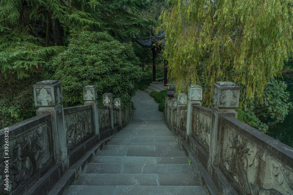 A Chinese stone bridge at the lakeside of West lake in Hangzhou, China, autumn time. A Chinese stone bridge at the lakeside of West lake in Hangzhou, China, autumn time.