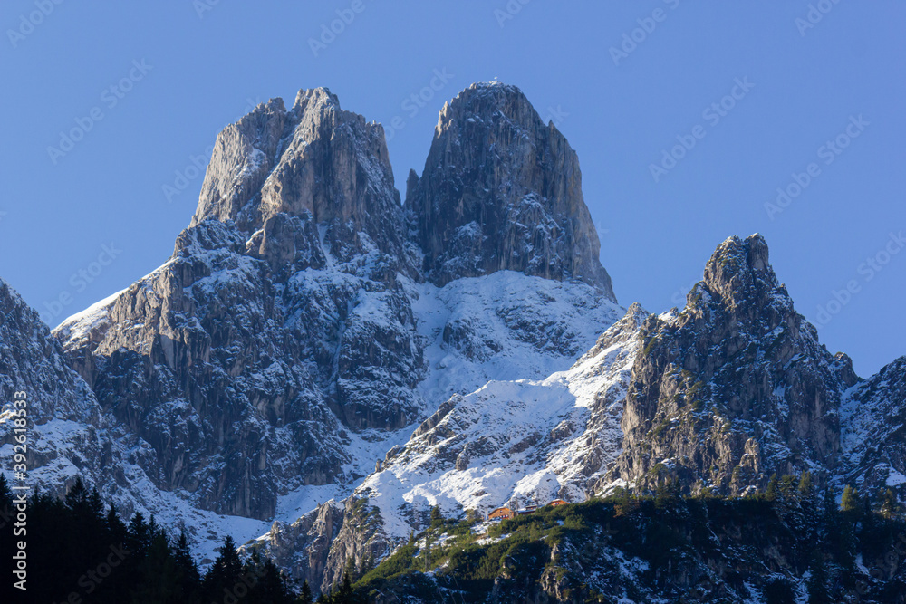 The 'Bishop's Mitre' (Bischofsmuetze) mountain peak during wintertime covered in snow with blue sky in the background (Filzmoos, Salzburg County, Austria)