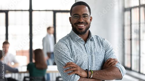 I made this. Portrait of ambitious confident black leader ceo standing with arms crossed on chest at office of successful profitable company looking at camera proud of his achievement career wellbeing