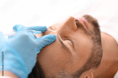 Closeup of bearded man getting beauty injection at clinic