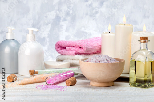 Aromatherapy, spa, beauty treatment and wellness background with massage oil, sea salt, towels, cosmetic products.
