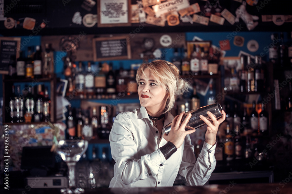 Girl barman concocts a cocktail in the saloon