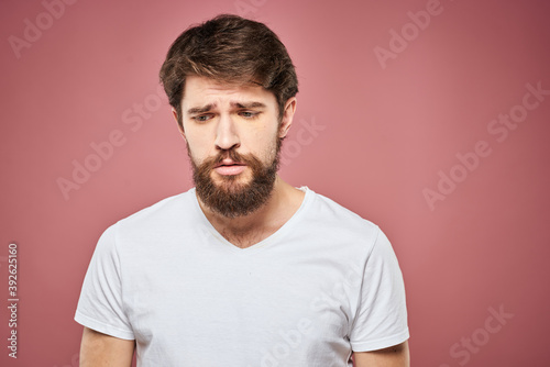 emotional man white t shirt sad facial expression pink background © SHOTPRIME STUDIO