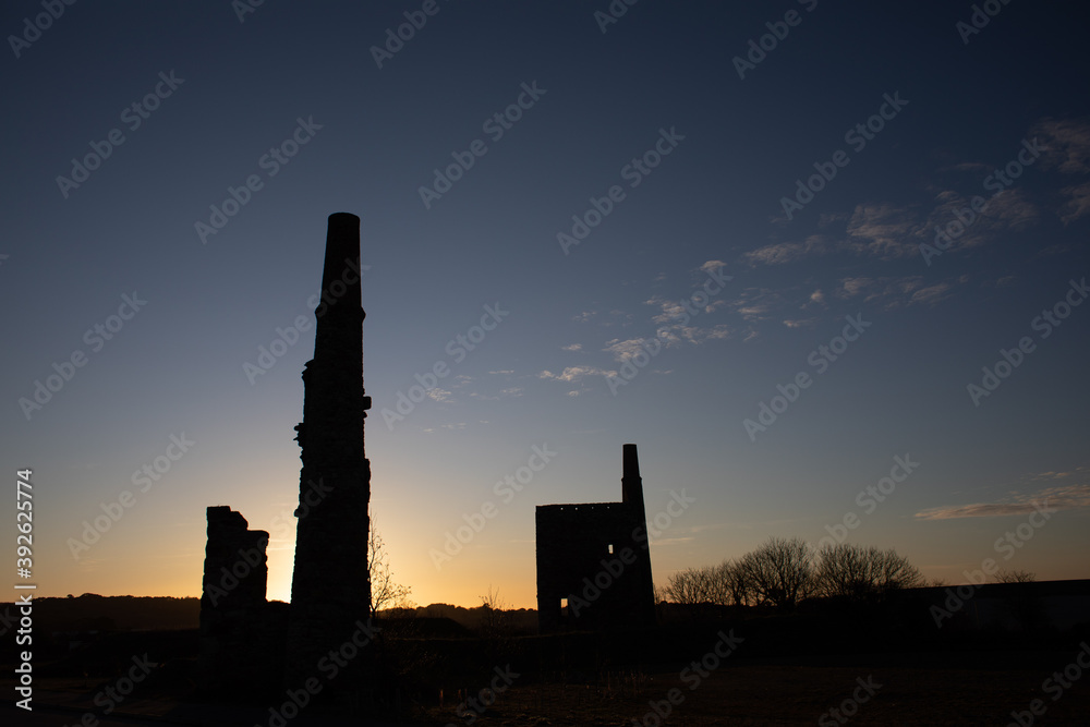 Silhouette of Cornish mine ruins, at sunset with an orange glow