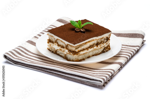 Traditional Italian Tiramisu square dessert portion on ceramic plate isolated on white background with clipping path