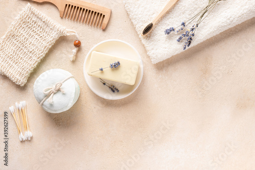 reusable cotton pads, natural soap bar, soap saver, wood comb, bamboo toothbrush, cotton swabs and lavender. Plastic free concept. Beauty and spa treatment. copy space, beige background.