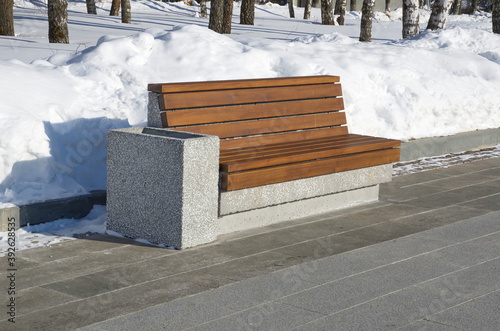 Wooden bench on a concrete base with an urn in the winter Park. Sergiev Posad, Moscow region, Russia