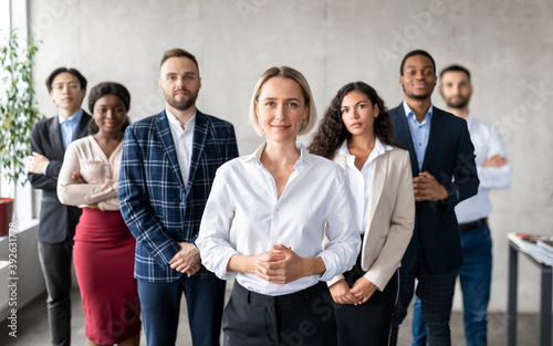 Successful Businesswoman Standing In Front Of Business Team In Office