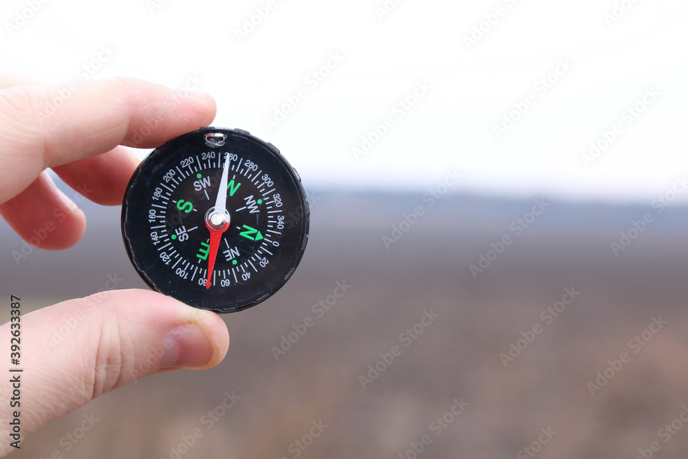 Old classic navigation compass in hand on natural background as symbol of tourism with compass, travel with compass and outdoor activities with compass Old classic navigation compass in hand on natural background as symbol of tourism with compass, travel with compass and outdoor activities with compass