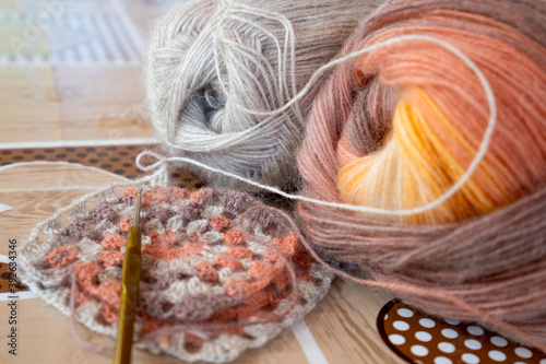 Close-up, grey and multi colored yarns and crochet needle. 