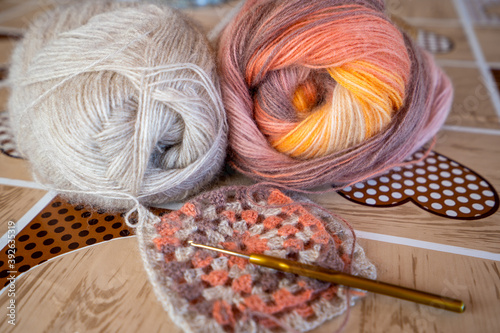 Close-up, grey and multi colored yarns and crochet needle. 