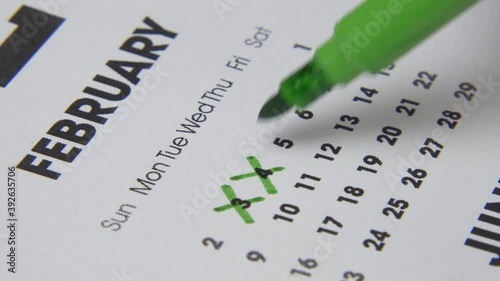 Macro shot date of month on calendar circled by green marker.