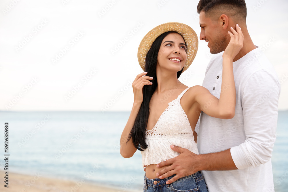 Obraz premium Lovely couple spending time together on beach. Space for text