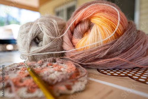 Close-up, grey and multi colored yarns and crochet needle. 