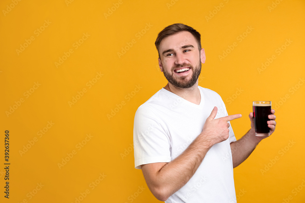 Handsome man with cold kvass on yellow background. Traditional Russian summer drink