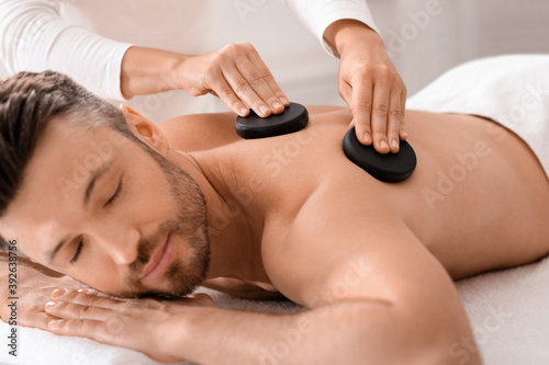 Closeup of man having hot stone massage at luxury spa