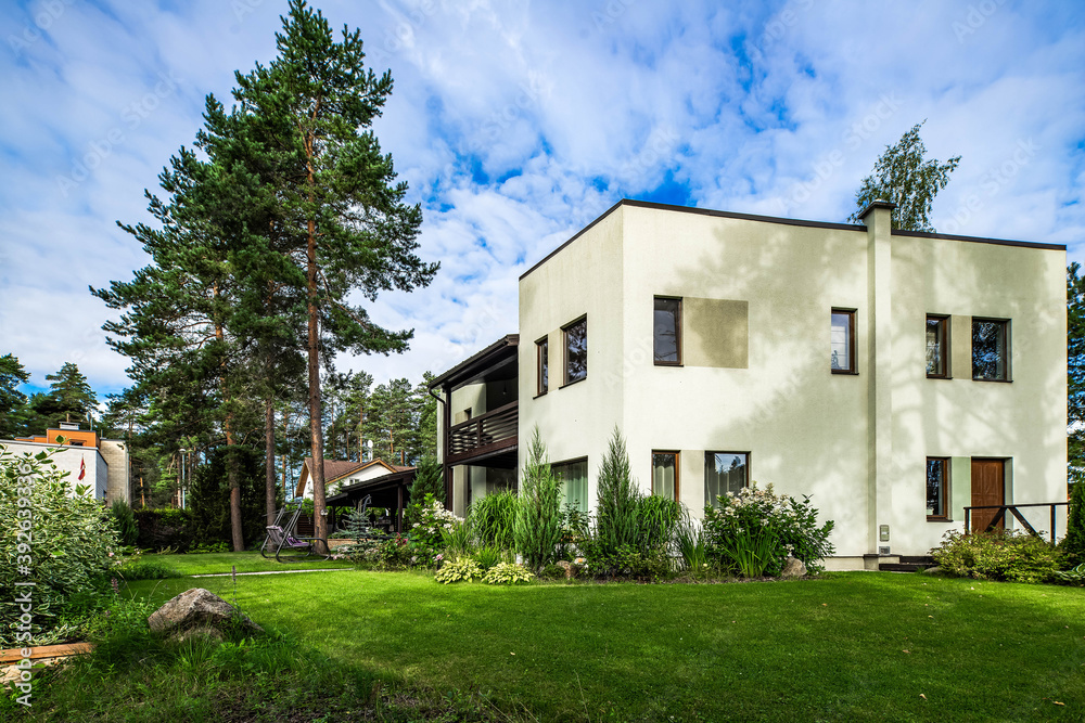 Garden of a private country house at summer cloudy day. Modern architecture. Exterior of cottage.