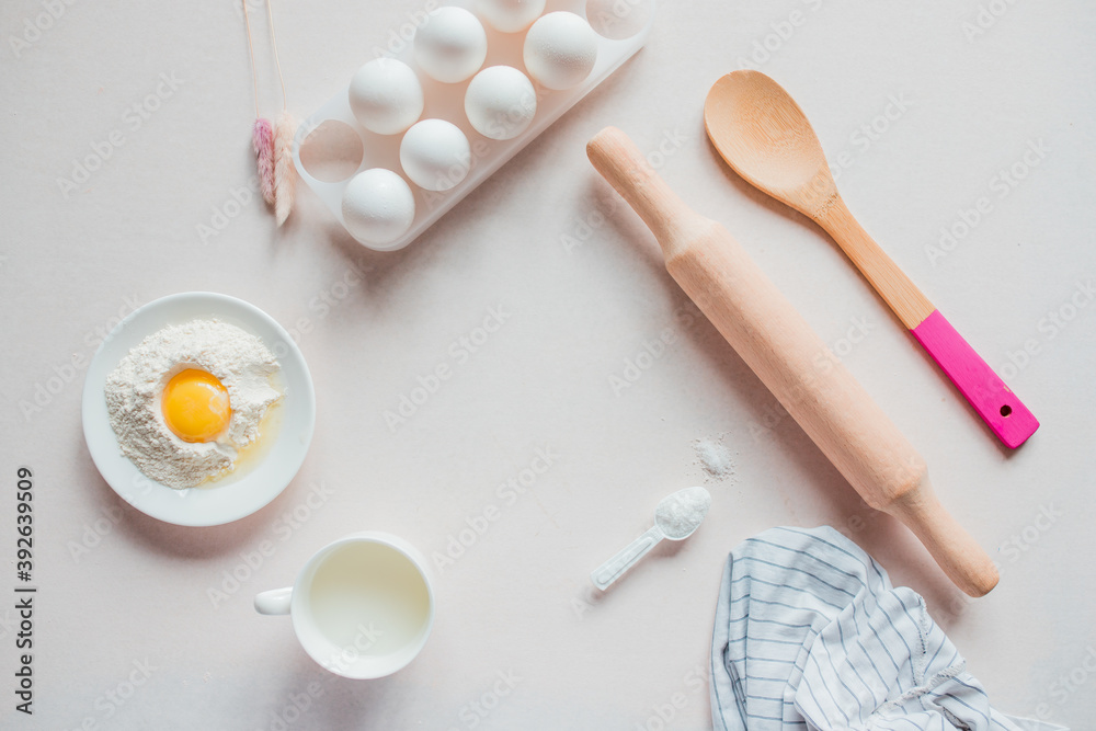 Ingredients for baking on a white background: eggs, flour, whisk, rolling pin. View from above. Copy space. workplace in the kitchen. Christmas kitchen atmosphere. Frame for cooking Ingredients for baking on a white background: eggs, flour, whisk, rolling pin. View from above. Copy space. workplace in the kitchen. Christmas kitchen atmosphere. Frame for cooking