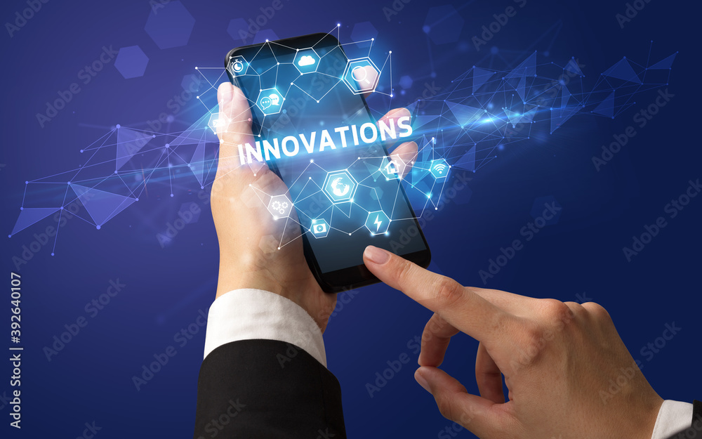 Female hand holding smartphone with INNOVATIONS inscription, modern technology concept Female hand holding smartphone with INNOVATIONS inscription, modern technology concept