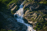 Waterfall on a rock face with green forest