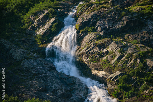 Fototapeta Naklejka Na Ścianę i Meble -  Waterfall on a rock face with green forest