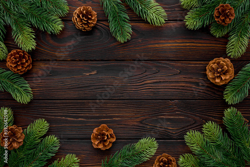 Spruce branch, cones and toys decoration on christmas or new year on dark wooden background.