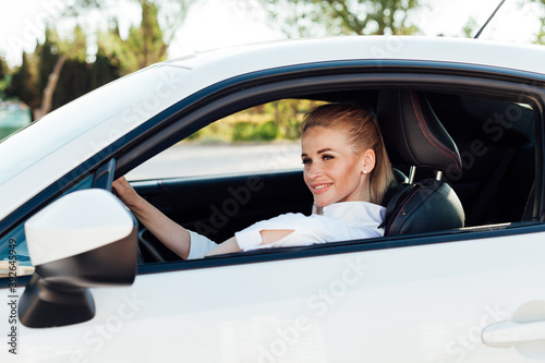 Beautiful female blonde driver behind the wheel of a car on the road © dmitriisimakov
